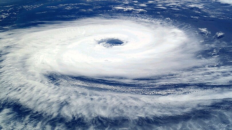 Tropischer Zyklon: weiße Wolken drehen sich in einer Spirale