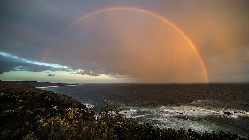 Ein Regenbogen an einer Küste