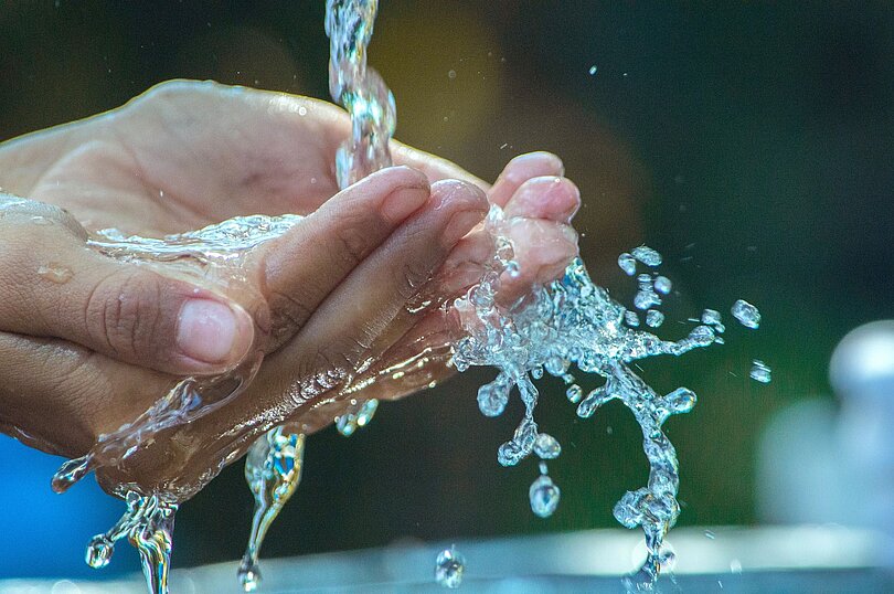 Zwei Hände, zu einer Schale geformt, die Wasser auffangen - wie zum Gesicht waschen. 